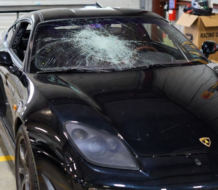 cracked windshield on a sports car parked in a garage